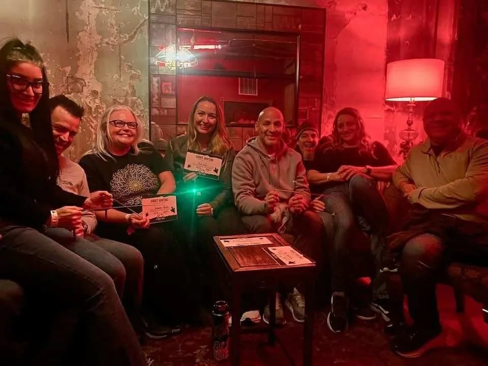Spooks & Spirits guests with ghost-hunting equipment in a red-lit room